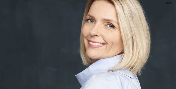 Mature Blond Female Smiling Over Shoulder